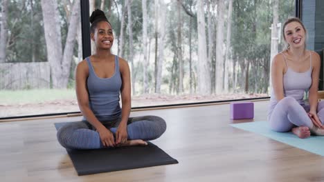 happy diverse women sitting on mats in yoga class, slow motion