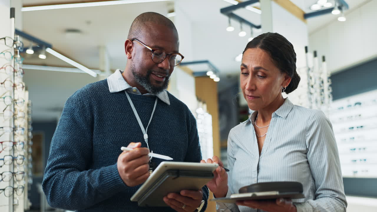 Optician assisting customer with glasses selection