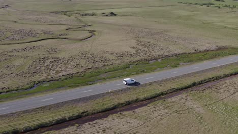 El-Coche-Viaja-A-Lo-Largo-De-La-Ruta-Escénica-En-La-Tierra-De-Hierba-Abierta-De-Islandia,-Antena