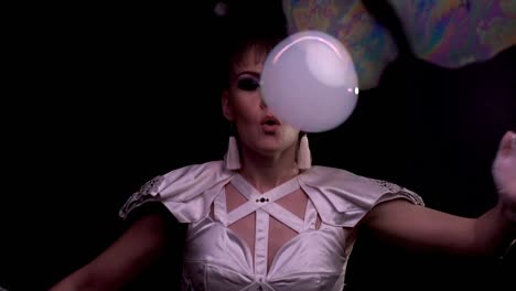 cu slow motion tricks with soap bubbles girl blowing on a bubble with smoke through a soap screen