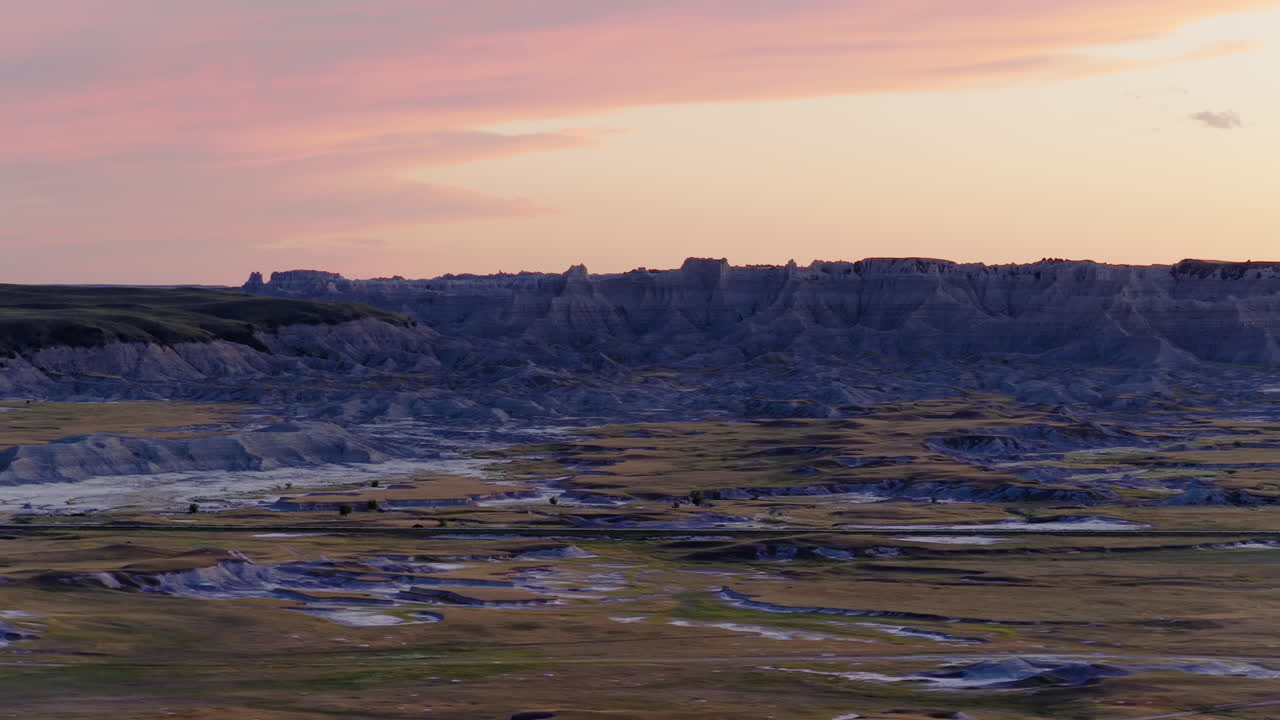 Sunset Journey Along Winding Road Carved Through Stark Badlands Terrain