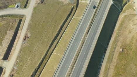 Traffic-on-highway-bridge-with-driving-cars-on-road-below-at-sunny-day