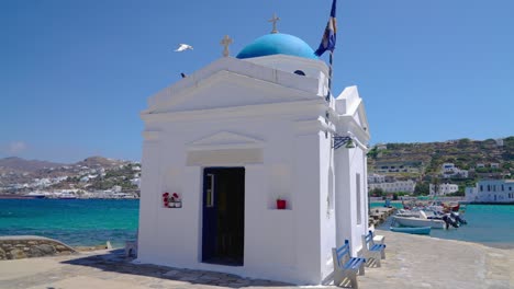 whitewashed and blue domed agios nikolaos church in the old town of mykonos, greece