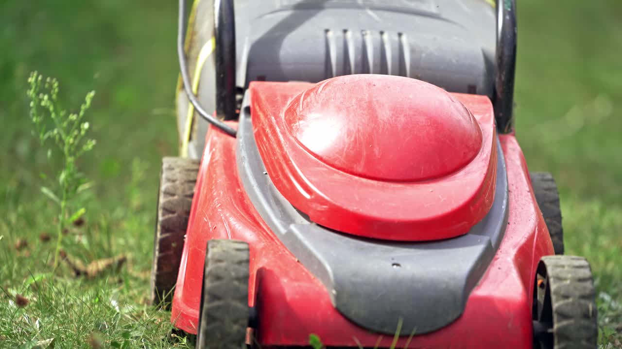 Man cutting grass with lawnmower. Close up view of lawn mower in the garden