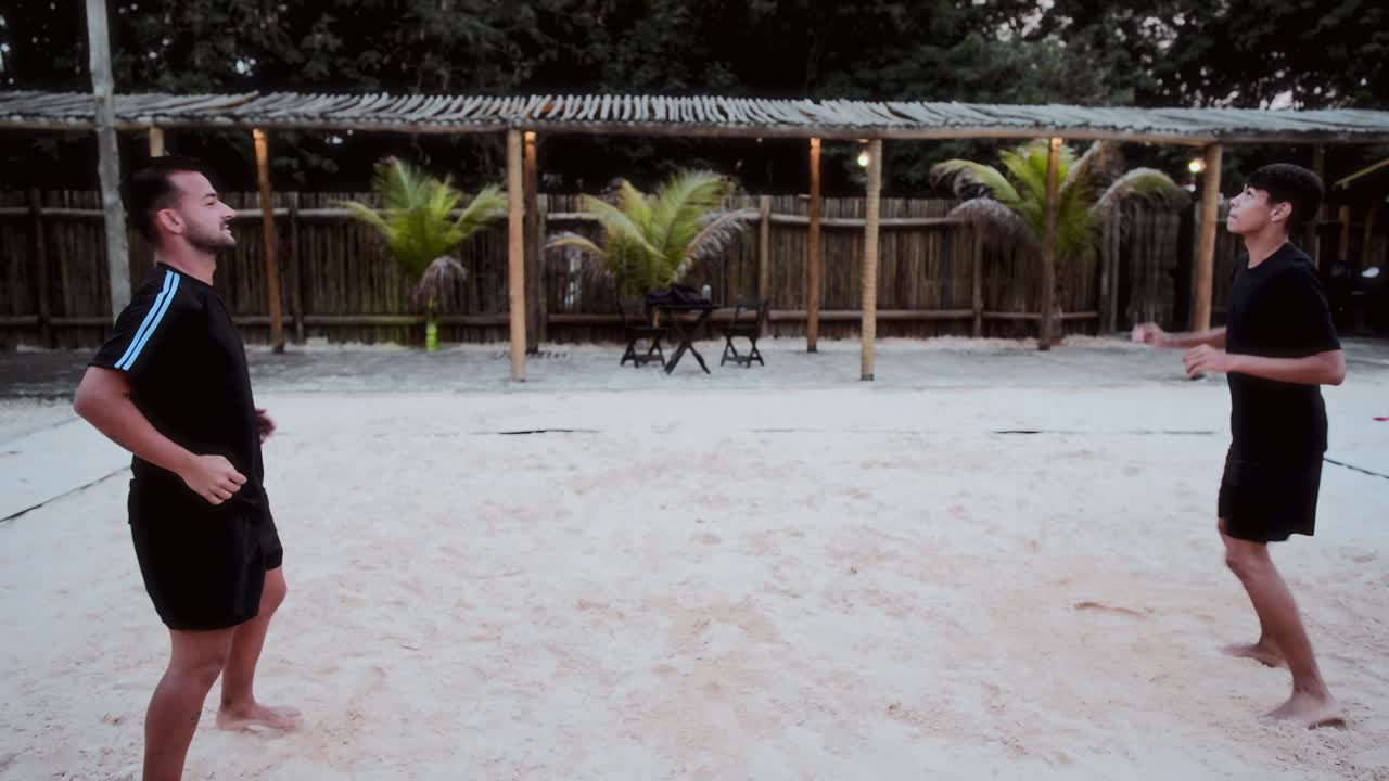 Men Playing Beach Volleyball on a Sand Court