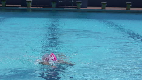 imágenes de una nadadora nadando vueltas en una piscina al aire libre usando la brazada de estilo libre como parte de su plan de entrenamiento de triatlón