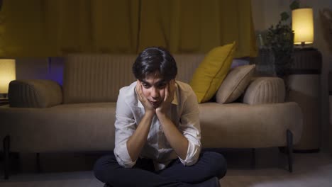 depressed man covering his face with his hand.