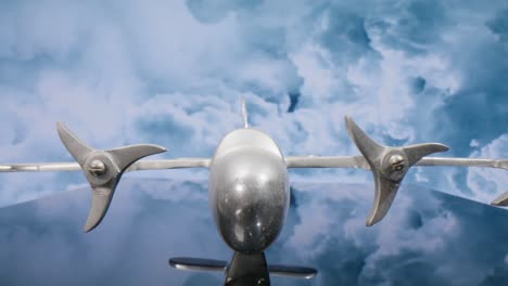 macro lens view of silver model airplane with clouds in the background and video moving in