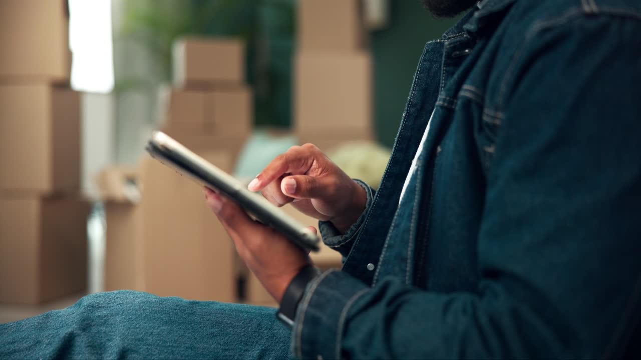 Person using tablet surrounded by moving boxes
