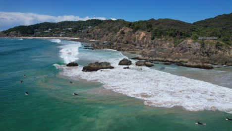 scenic seascape with surfers at clarkes beach, new south wales, australia - drone shot