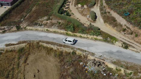 vehículo blanco viaja por carretera a la ubicación turística wied il-għasri en gozo, malta