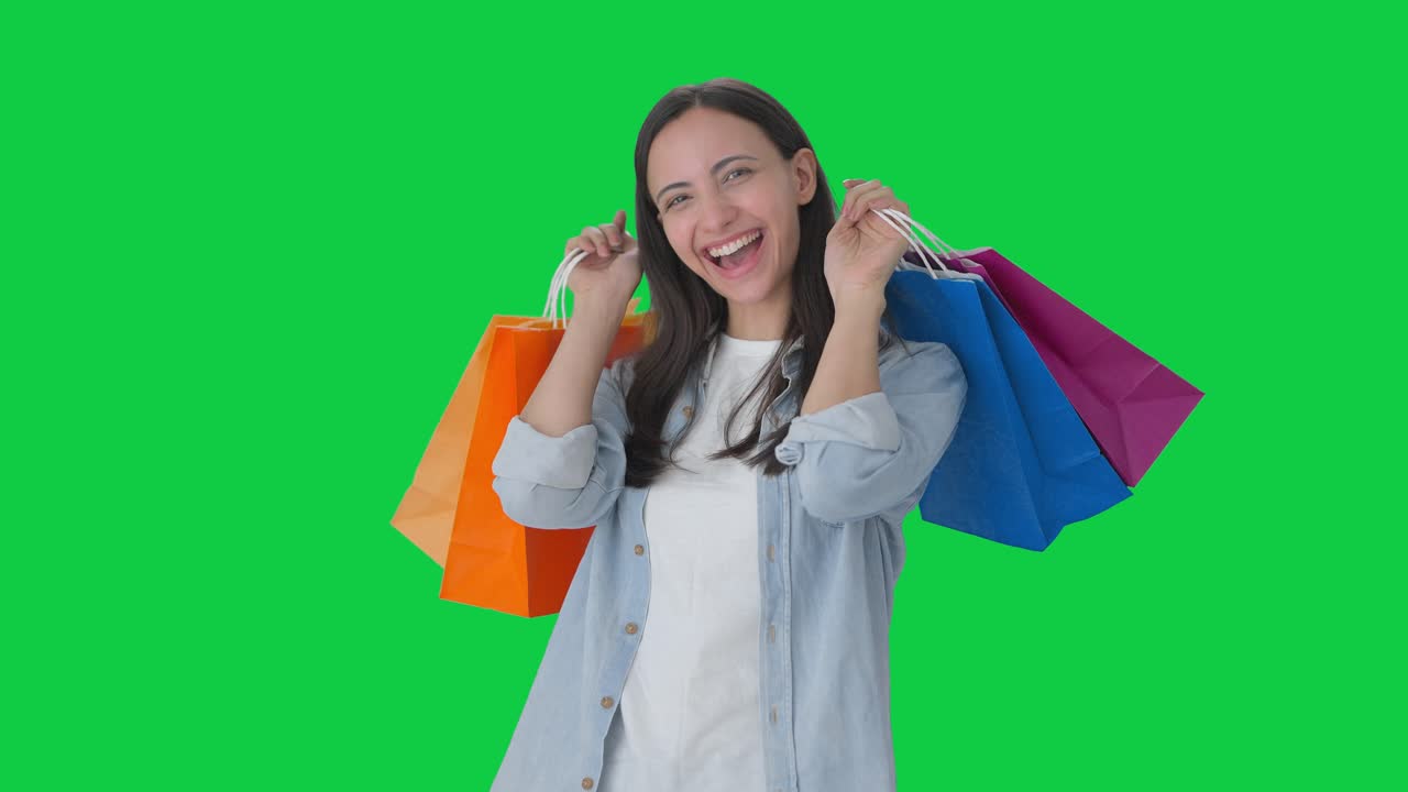 chica india feliz haciendo un montón de compras pantalla verde