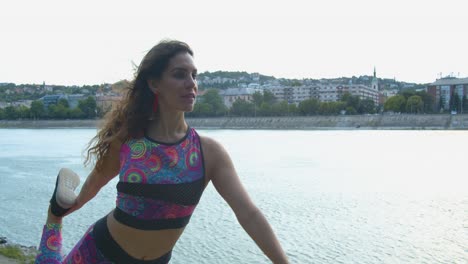 mujer joven haciendo yoga de pie junto al río danubio