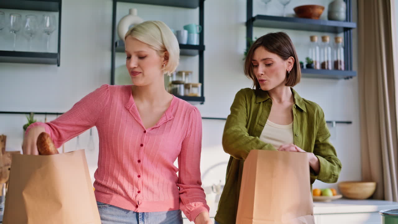 Twee vrouwen brengen boodschappen, close-up van keuken. Lgbt-stel deelt huishoudelijke taken