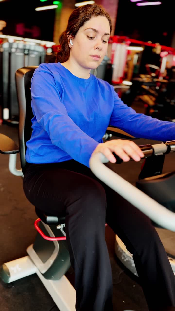 Woman using recumbent exercise bike at the gym