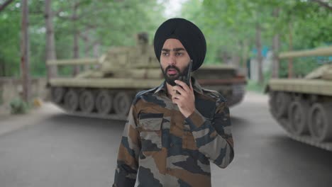 serious sikh indian army man giving instructions on walkie talkie