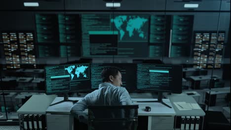 back view of asian man developer having backache while write code with multiple computer screens in the office