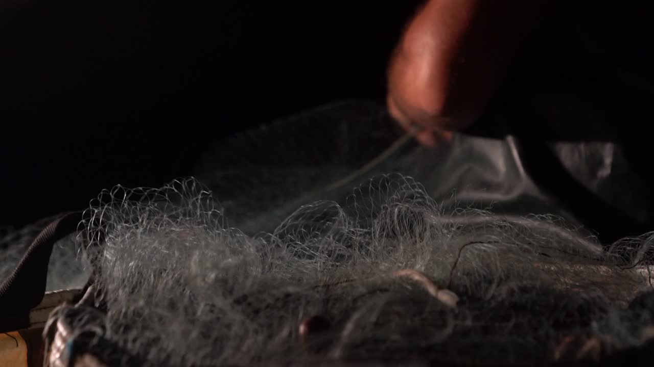 밤에 배에서 어망을 당기는 어부의 클로즈업