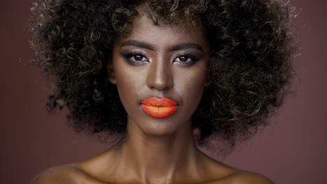 retrato de una mujer con maquillaje audaz y cabello rizado