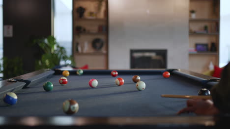 a group of friends gathers around a billiards table in a stylish lounge. the vivid balls are arranged in a relaxed setting, creating a fun environment for games.