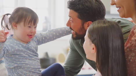 Familie-Mit-Down-Syndrom-Tochter-Backt-Und-Dekoriert-Kuchen-Und-Sitzt-Zu-Hause-Am-Tisch