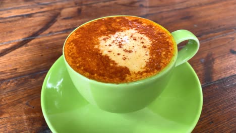 a turmeric latte with coconut milk and cinnamon powder on top