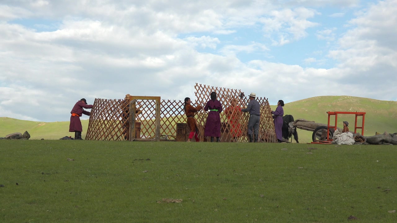 Mongolische Familie baut ein traditionelles Jurtenzelt in der Steppe auf