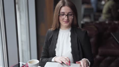 Woman-sipping-coffee-while-working-on-a-laptop