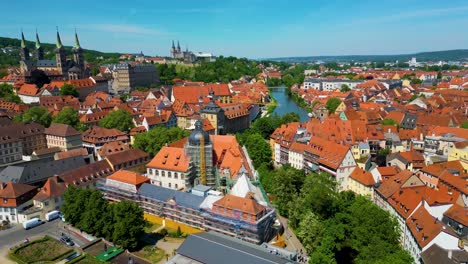 4k aerial drone video of construction cranes near the bamberg cathedral and michaelsberg abbey along the regnitz river in the historic old town area of bamberg, germany