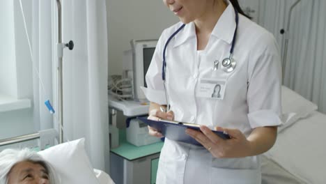 elderly lady talking with doctor in hospital ward