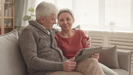 older couple using tablet on couch