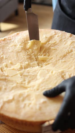 cutting a wheel of cheese