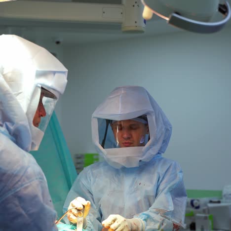 serious doctor in safety uniform. surgeon during the operation in the intensive care unit in hospital. pandemic concept.