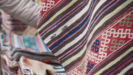 colorful handwoven rugs on display at a market