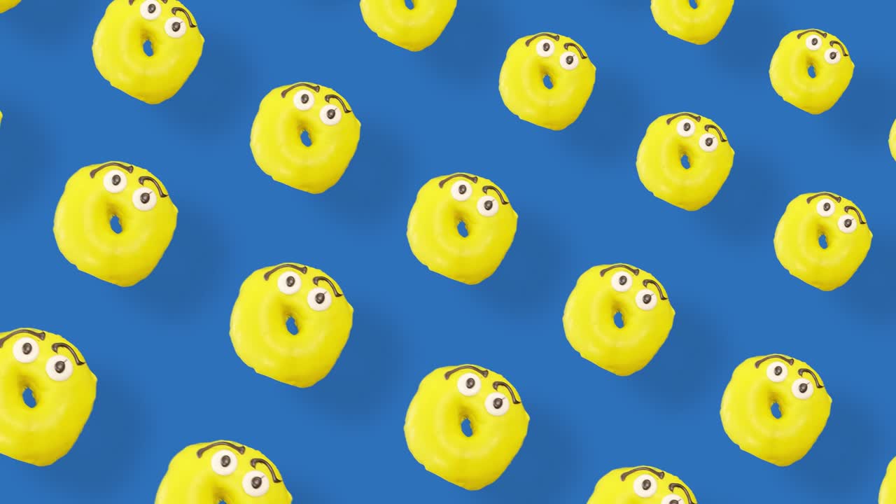 Colorful pattern of donuts isolated on blue background with shadows. Seamless pattern with donut. Doughnuts. Top view. Realistic animation. 4K video motion