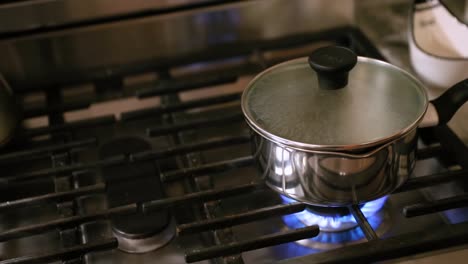 panning shot of water boiling on stovetop in slow motion