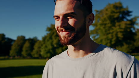 happy bearded man smiling and laughing outdoors in sunlight