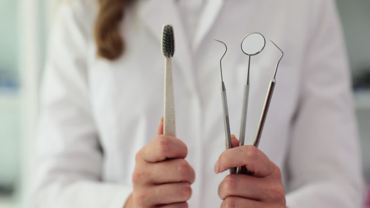 Dentist holding dental tools and a toothbrush