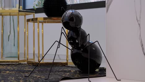 slow establishing shot of an ant decoration sat beside golden tables in a villa