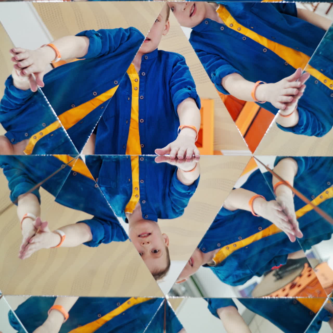 Boy's hands guestures in many parts of kaleidoscope reflection. Geometric design of a happy child playing on the background of mirror in kaleidoscope