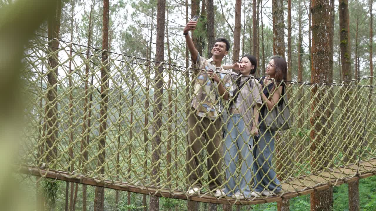 Asian Friends Taking Selfie on Forest Rope Bridge in Indonesia