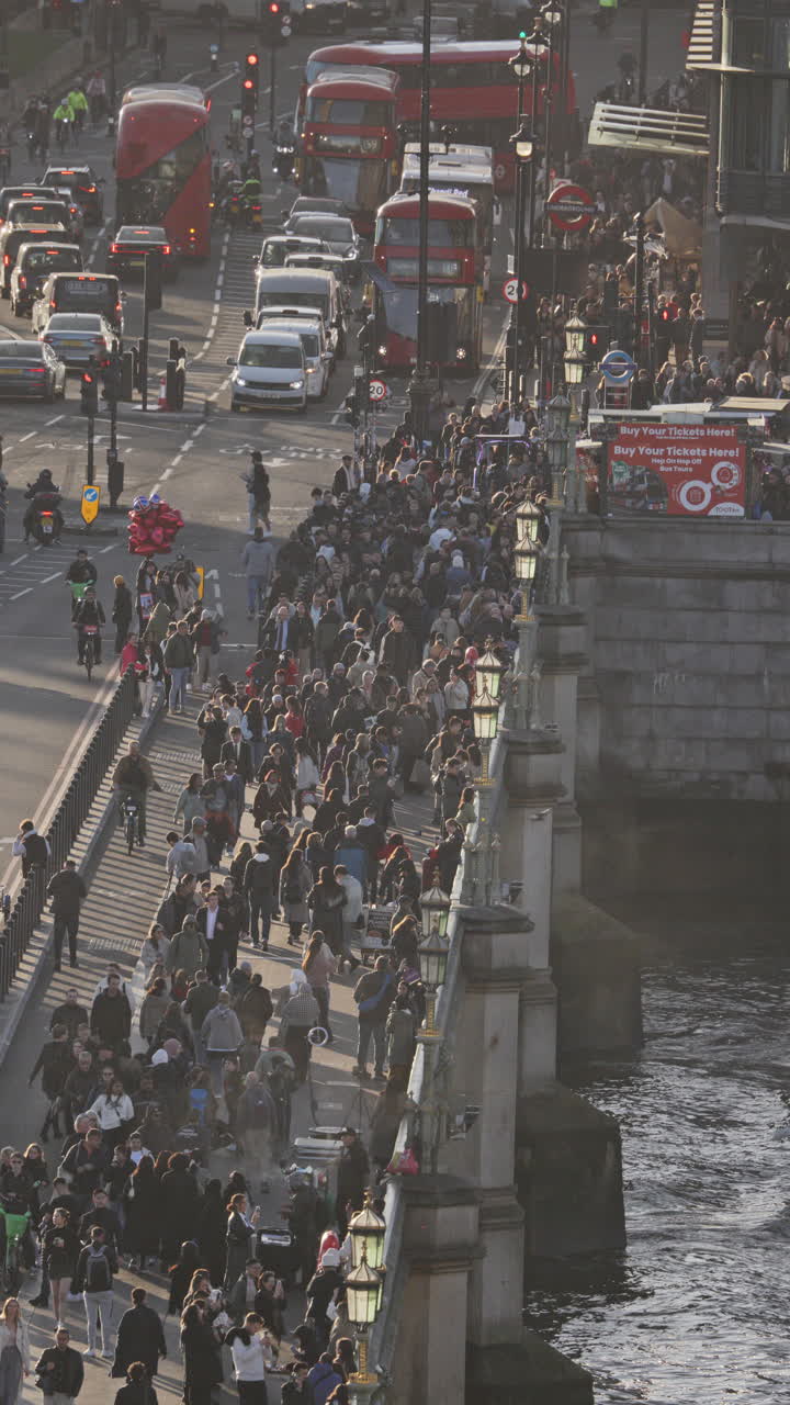 el tráfico y la gente que cruza el puente de westminster al lado de las casas del parlamento, londres, reino unido en vertical