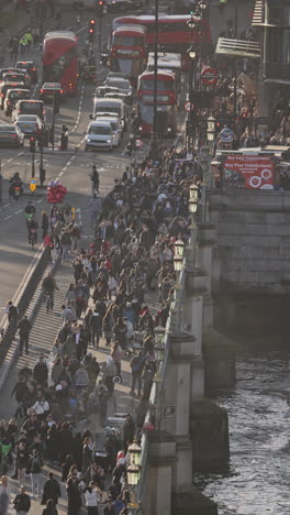 traffic and people crossing westminster bridge next to the houses of parliament, london, uk in vertical