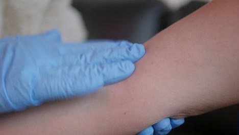 close-up of a nurse tapping the arm to find a good vein to draw blood during venipuncture