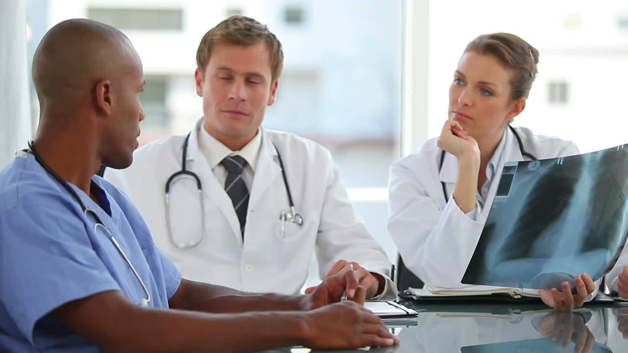 Three doctors talk to a nurse