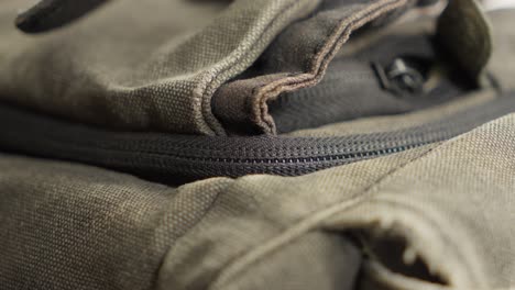 A-hand-zipping-up-a-brown-canvas-bag-in-a-close-up-shot