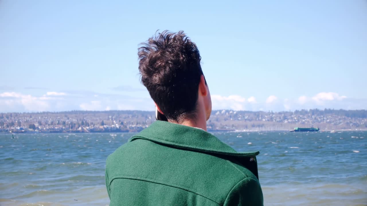 ⁇ 은 날 해변에서 휴대전화로 이야기하는 남자 4k