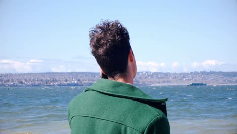 hombre hablando por teléfono móvil en la playa en un día soleado 4k
