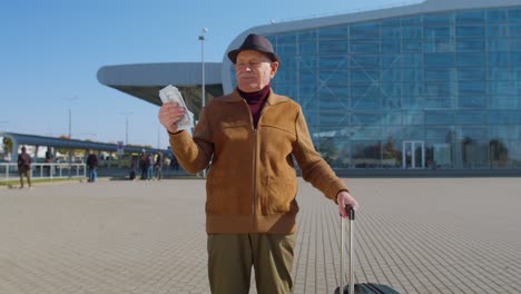 anciano jubilado rico negocio turista abuelo quedarse cerca de la sala del aeropuerto mantener dinero dólares en efectivo