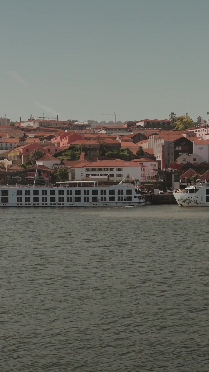 Fiume Douro con gli edifici lungo la riva di Porto e una barca turistica ormeggiata.